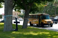 En skolbuss passerar ett kors som placerats ut i Uvalde för att hedra de som dödades i skolskjutningen på skolan Robb Elementary. Arkivbild.