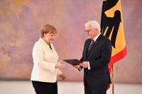 Tysklands president Frank-Walter Steinmeier lämnar över utnämningsbrevet till förbundskansler Angela Merkel vid en ceremoni i slottet Bellevue i Berlin.