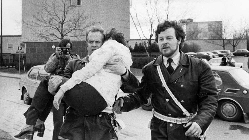 En kvinna ur gisslan sätts i säkerhet av polisen i samband med tyska vänsterextremisters ockupation av västtyska ambassaden i Stockholm 1975.