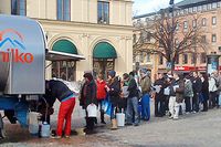 Karlstadbor köar för att få vatten ur tankbilen som står uppställd på Stora torget i Karlstad.