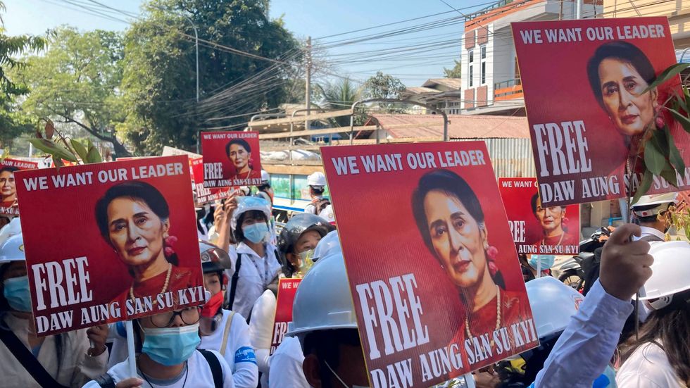 Demonstranter i staden Mandalay håller upp porträtt på Myanmars avsatta folkvalda ledare Aung San Suu Kyi och kräver att hon ska friges.