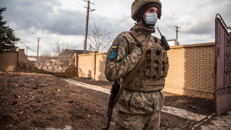 En ukrainsk soldat invid hus i en by i det ryskstödda utbrytarområdet Luhansk på lördagen.