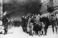 Judar från Warszawas getto förs ut av SS-soldater till sin undergång i koncentrationslägren.
