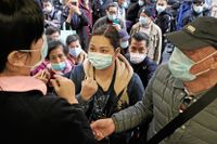 Människor köar utanför en affär i Hongkong för att köpa munskydd.