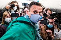 Aleksej Navalnyj omringad av journalister på planet.