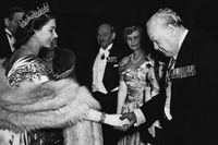 Drottningens första premiärminister. Elizabeth, då prinsessa, skakar hand med Winston Churchill under en middag i London 1950.