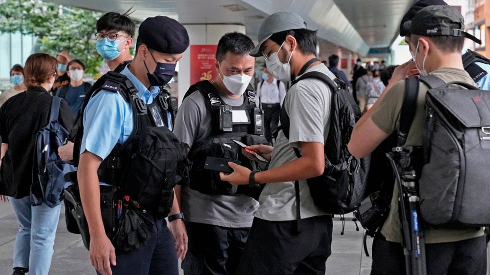Polis i Hongkong stoppar journalister för att kontroll inför regionalt regeringsbyte i somras. Arkivbild.