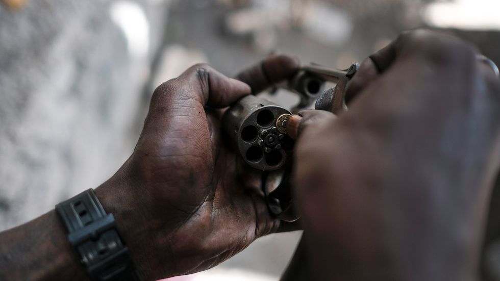 En gängmedlem i Port-au-Prince visar upp sitt vapen. Arkivbild.