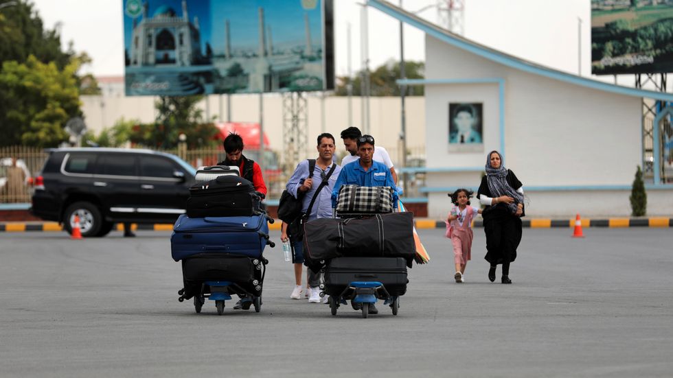 Passagerare vid Kabuls internationella flygplats i lördags. Allt civilflyg är nu inställt vid flygplatsen, och även rutter som bara går i Afghanistans luftrum läggs om.