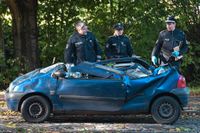 Poliser vid en bil som skadats av fallande träd i Hamburg i norra Tyskland.