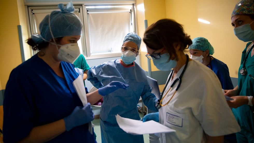 En sjuksköterska informerar sin kollega om läget för coronapatienterna på sjukhuset San Carlo i Milano i Italien. Bilden är från torsdagen den 16 april.