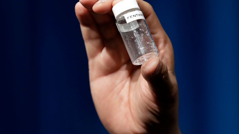 A reporter holds up an example of the amount of fentanyl that can be deadly after a news conference about deaths from fentanyl exposure, at DEA Headquarters in Arlington Va. 