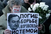 En kvinna håller upp upp ett plakat med en bild av Sergej Magnitskij vid en demonstration i Moskva i förra veckan.