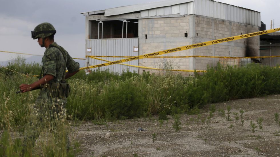 En soldat på vakt utanför ett lagerhus där tunneln som "El Chapo" använde sig av slutar.