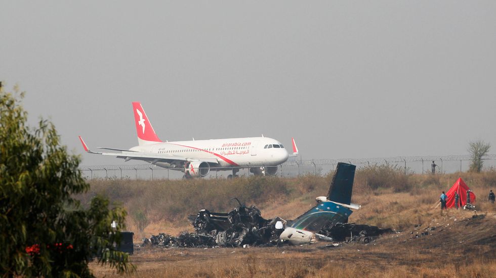 Det utbrunna US-Bangla-flygplanet bredvid landningsbanan i Nepal den 13 mars 2018, dagen efter kraschen.