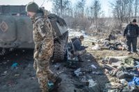 Ukrainska soldater inspekterar ett ryskt pansarfordon.
