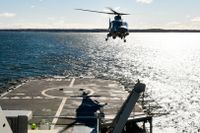 En helikopter lyfter från lednings­fartyget HMS Carlskrona under en marinövning i Stockholms skärgård, april 2022.