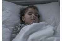 Tvåårige Iman sover i en sjukhussäng i Jordanien. 