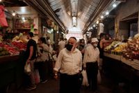 Besökare med mundskydd på Machane Yehuda-marknaden i centrala Jerusalem, timmar innan Israels andra nedstängning träder i kraft.