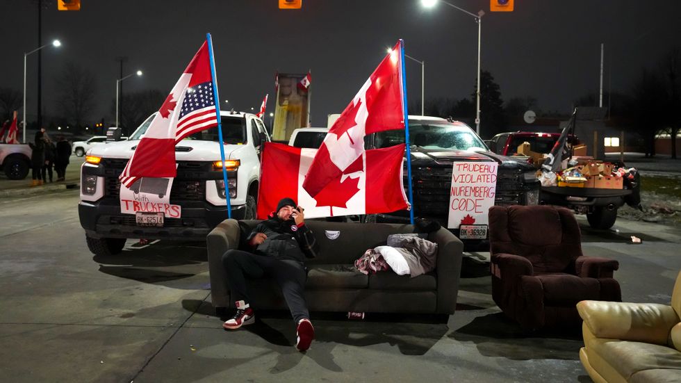 En man från proteströrelsen sitter i en soffa vid påfarten till Ambassador Bridge som kopplar samman Detroit i USA med kanadensiska Windsor.