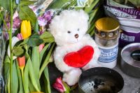 På platsen där en 15-åring mördades i Skogås har människor lagt blommor, ljus och en nalle. 