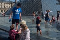 Fontänerna vid Louvren ger svalka i den extrema hettan i Paris.