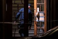 Polis på plats vid entrén till ett flerfamiljshus på Kastellgatan i Malmö natten till måndagen efter en skottlossning.