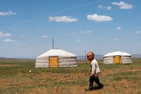 En mongolisk pojke utanför sin jurta – för att använda ett reflexivt possessivt pronomen.