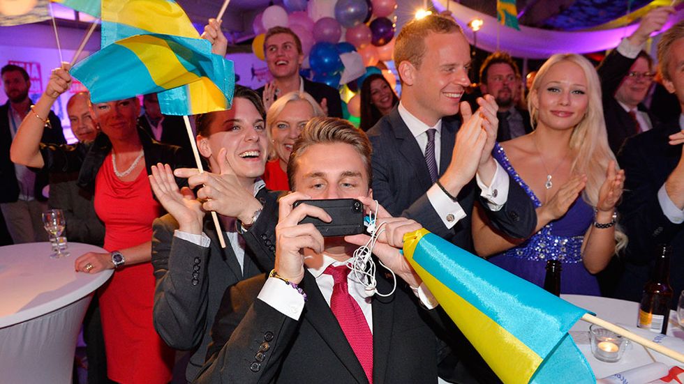 Sverigedemokrater firar på valvakan på Vasavarvet i Stockholm på söndagskvällen.