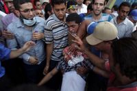 En skadad man bärs bort från Ramsestorget i Kairo, där många dödades på fredagen.