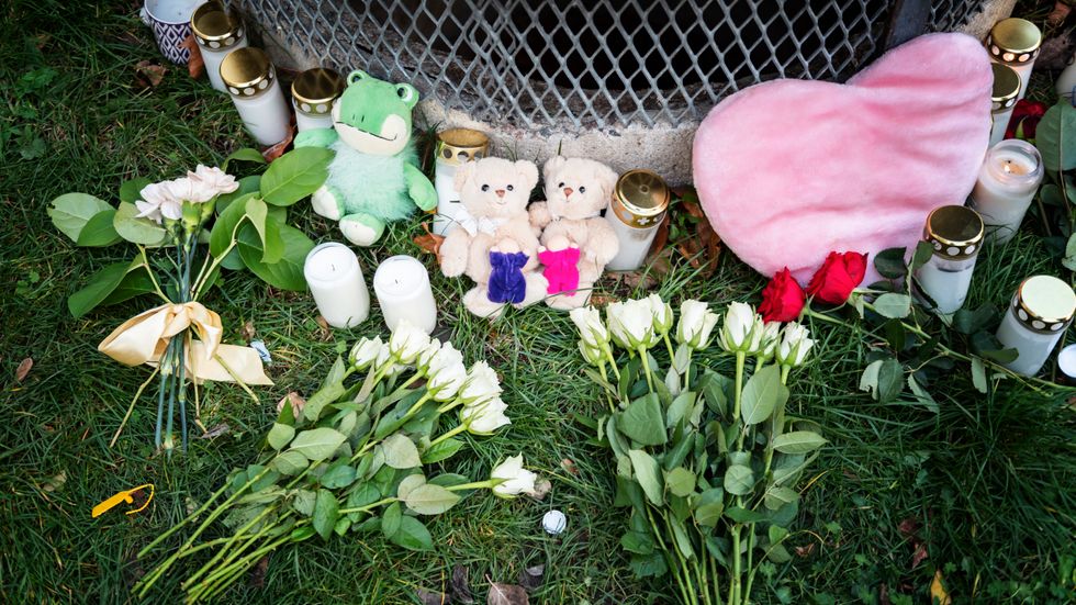 Gosedjur, blommor och ljus har lagts ner vid den plats där två barn hittades med livshotande skador utanför ett bostadshus i Hässelby i söndags kväll. 