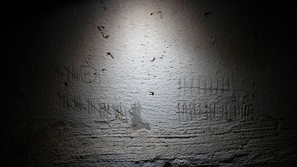 Inristade streck – troligen ristade för att räkna dagar – på väggen i en källare som användes som en rysk tortyrkammare i Cherson. Bild från december 2022.