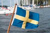 Svenska flaggan i aktern på en fritidsbåt.
