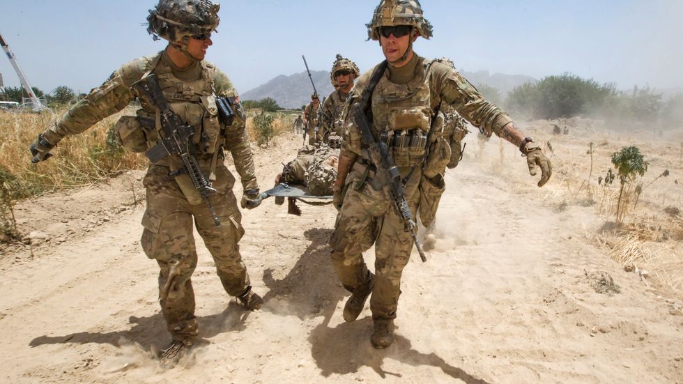 Amerikanska soldater bär en av de sina som skadats i en explosion i södra Afghanistan, juni 2012. De följer soldatregeln – man överger inte de sina.