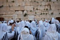 Judiska män ber under den judiska påsken pesach framför Västra muren, en del av Tempelbergets stödmur, på söndagen.