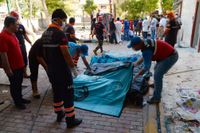Räddningsarbetare tar hand om döda kroppar efter explosionen i Suruc på måndagen som dödade minst 30 personer.