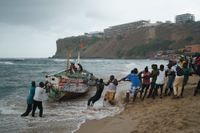 Lokalbor försöker dra upp den båt som de döda migranterna tros ha färdats i.