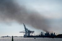 En svart rökpelare stiger mot skyn efter en brand i Göteborgs hamn.