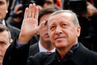 President Erdoğan vinkar åt sina anhängare när han lämnar en vallokal på söndagen.
