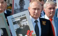 Vladimir Putin håller ett porträtt av sin far som stred i andra världskriget. Rysslands stolthet över att ha vunnit över nazisterna används i dag som propaganda för att motivera aggressionen mot Ukraina. 