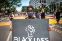 En ung kvinna demonstrerar för rörelsen Black lives matter utanför Vita huset i Washington DC.