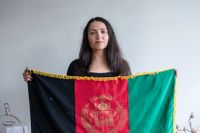 I sitt hem i Skogås håller Boshra Waziri upp Afghanistans flagga – i protest mot talibanernas svarta och vita fana som vajar i hennes ursprungsland.