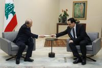 Libanons premiärminister Hassan Diab, till vänster, överräcker regeringens avgångsansökan till president Michel Aoun.