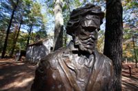 En staty av Thoreau framför en reproduktion av hans stuga vid Walden Pond.