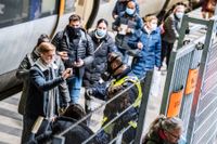 Polis i skyddsmask kontrollerar resenärer som ankommit från Danmark med Öresundståg på perrongen på Hyllie station i Malmö. Arkivbild från december 2020.