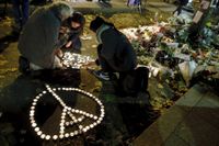 Folk tänder ljus i Paris för att hedra offren för terrordåden.