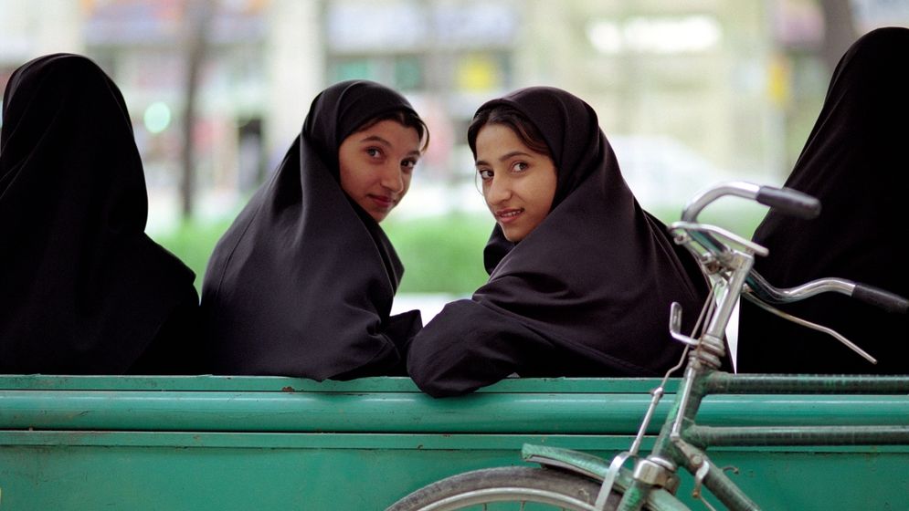 Unga muslimska kvinnor vid en busshållplats i Esfahan, Iran.