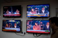 Pakistansk tv visar överlämnandet av den gripne indiske piloten (till höger). På bilden ses han passera en gränsövergång mellan länderna.