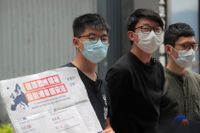 Demokratiaktivisterna Joshua Wong (till vänster), Sunny Cheung (mitten) och Nathan Law med ett plakat som uppmanar europeiska ledare att ta strid mot Kinas planer på att beskära Hongkongs autonomi genom en ny nationell säkerhetslag.