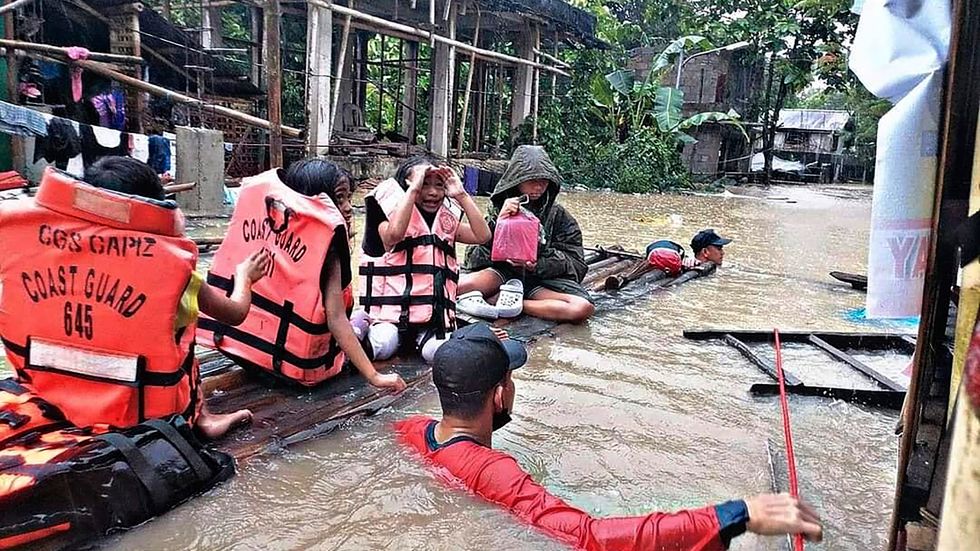 Kustbevakningen evakuerar människor i byn Panitan på ön Panay under tisdagen.
